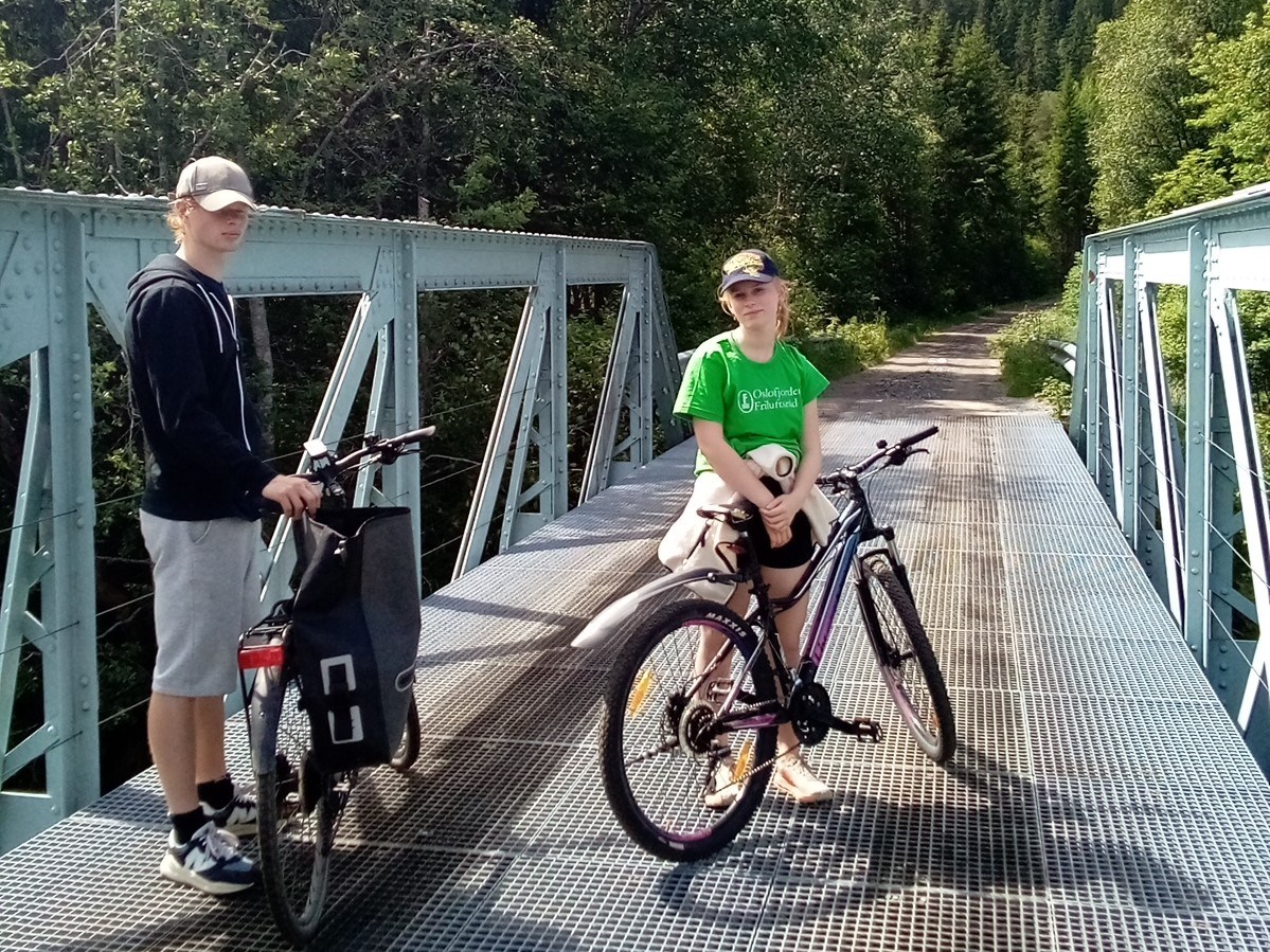 Sommerstudentene Elisabeth og Oskar på hver sin sykkel, på en turvei.