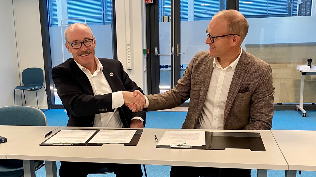 Direktør Ole Arve Misund frå Norsk Polarinstitutt og kartverkssjef Johnny Welle signerar samarbeidsavtale.