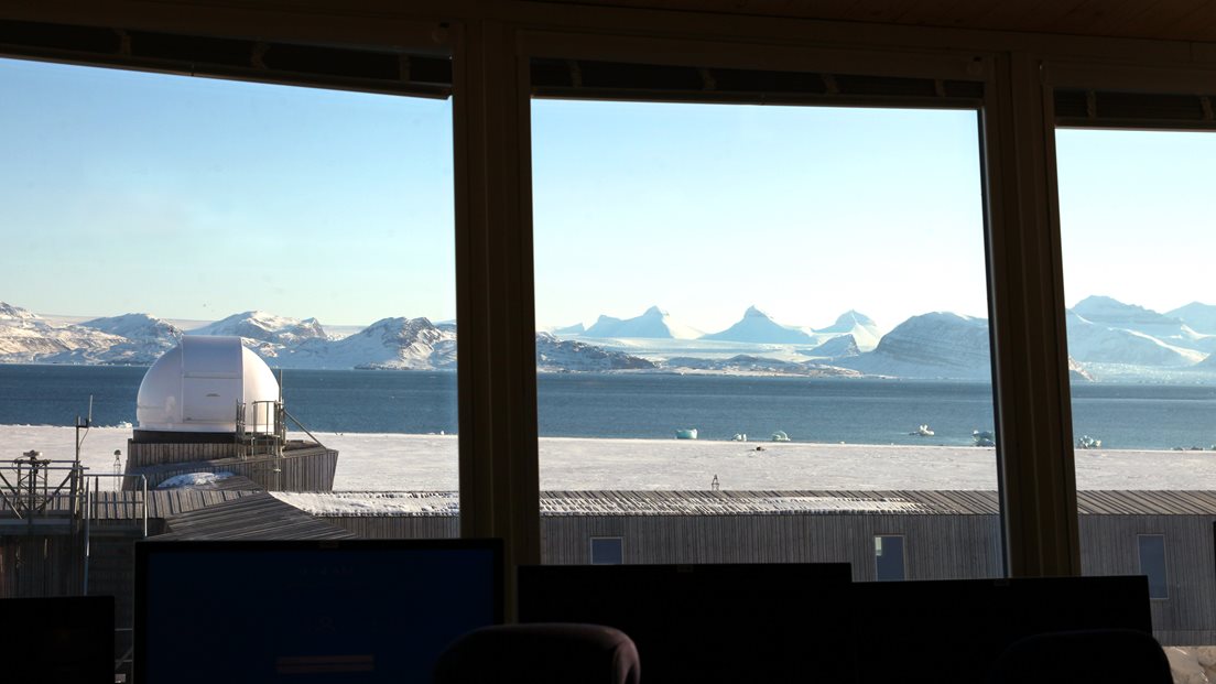 Utsikt fra innsiden av observatoriet mot vinterkledte fjell