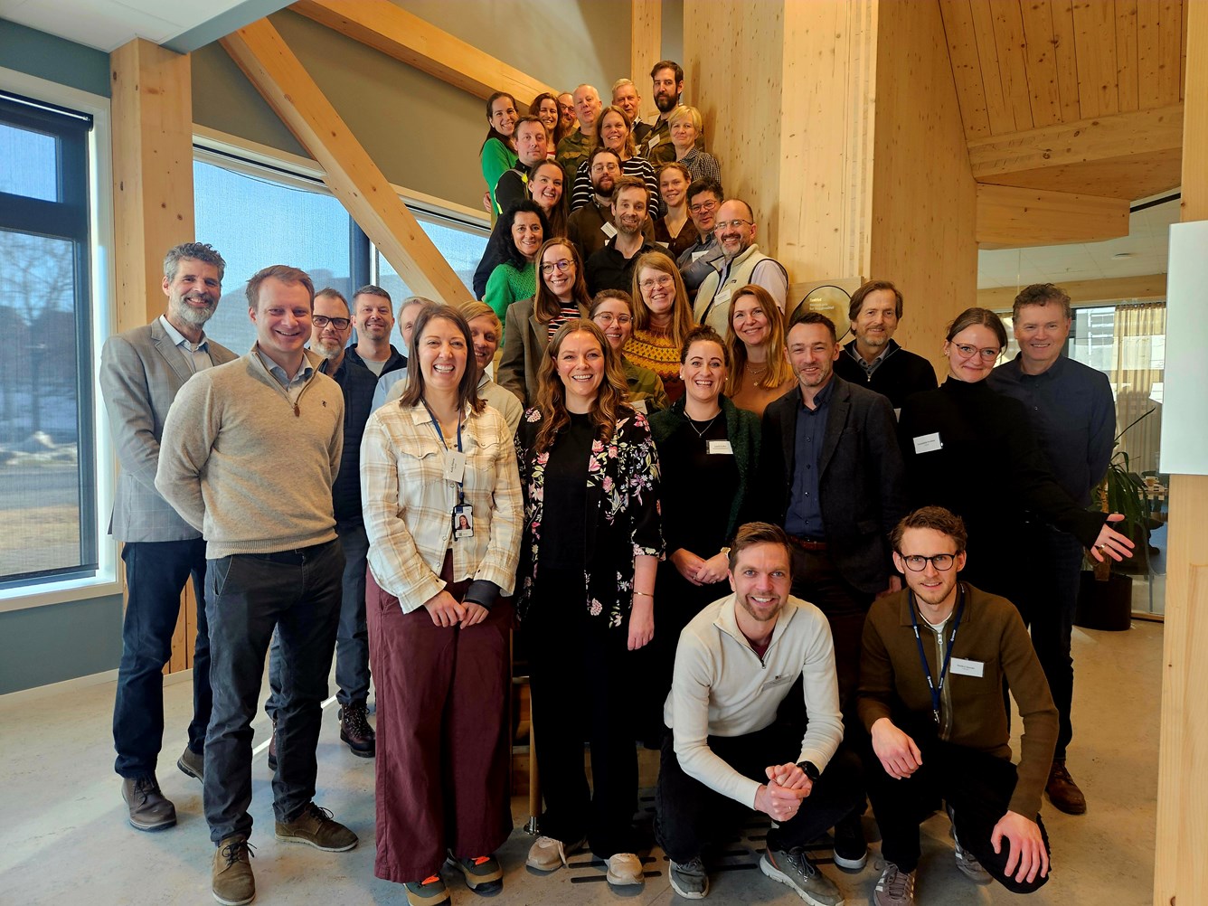 Fellesbilde med smilende mennesker foran og i en trapp.