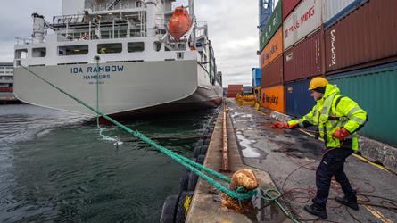 Mann fortøyar skip i pullert i Kristiansand hamn. Foto.