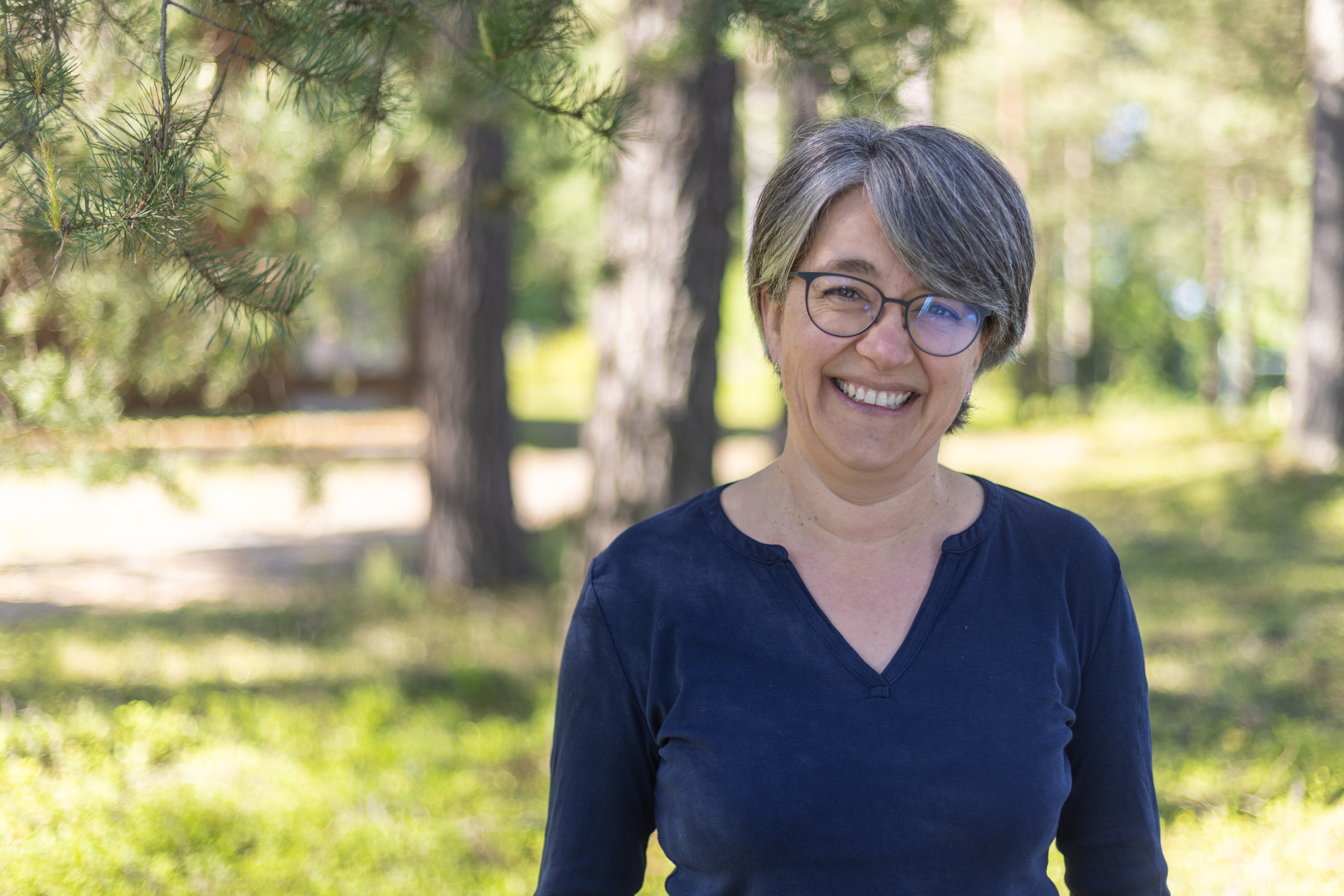 Kvinnelig ansatt i Kartverket fotografert utend&oslash;rs i skogen