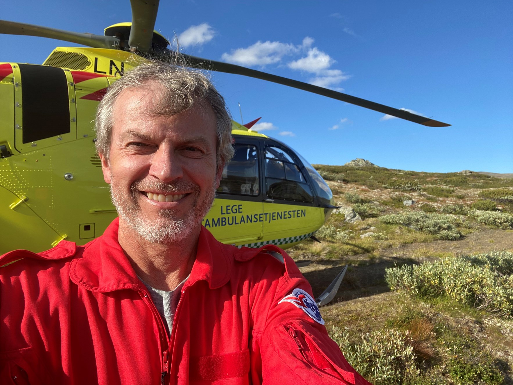Helikopterpilot Erlend Segtnan foran helikopter fra Norsk luftambulanse