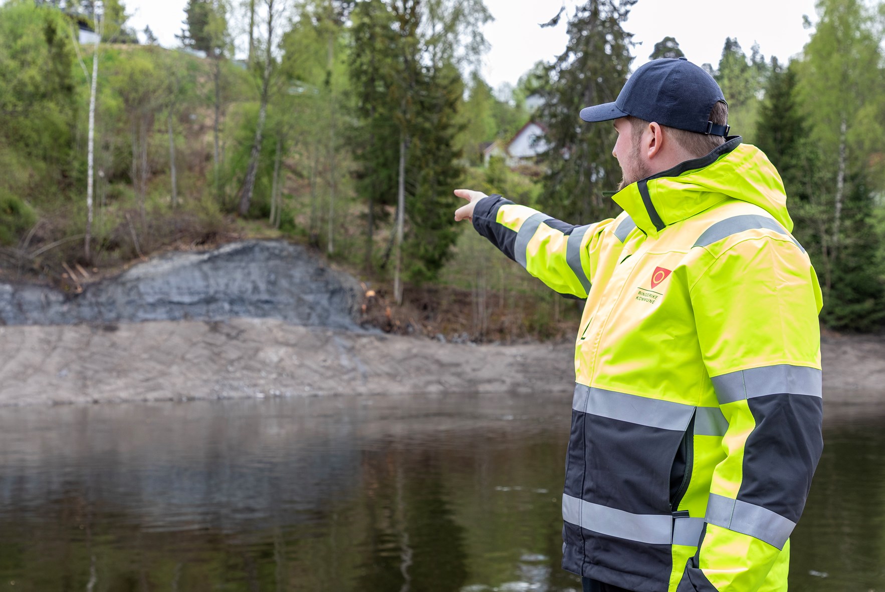 Geolog Marius Karlseni Ringerike kommune peker på utrast parti av Randselva. (Foto: Åsgeir Størdal/ Kartverket)