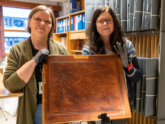 To ansatte ved Kartverket holder trykkplate i kobber