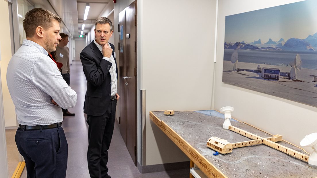 Statsråd og departementsansatte foran modell av Kartverkets jordobservatorium i Ny-Ålesund. Foto: Åsgeir Størdal/ Kartverket