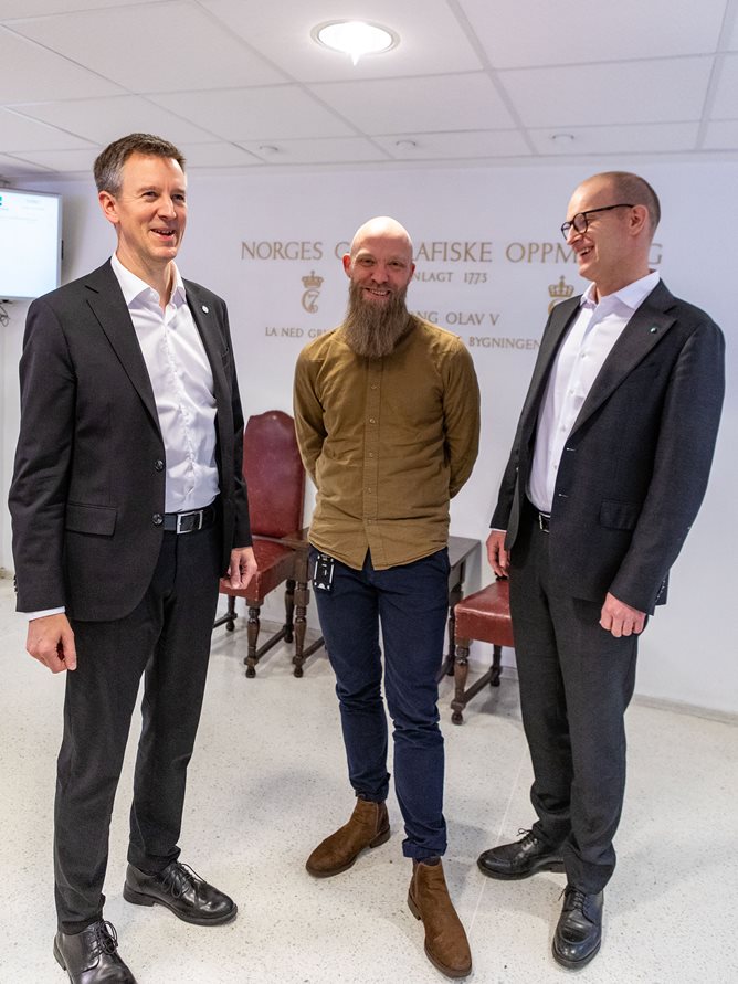 Tre menn i resepsjonen til Kartverket på Hønefoss. Foto: Åsgeir Størdal/Kartverket