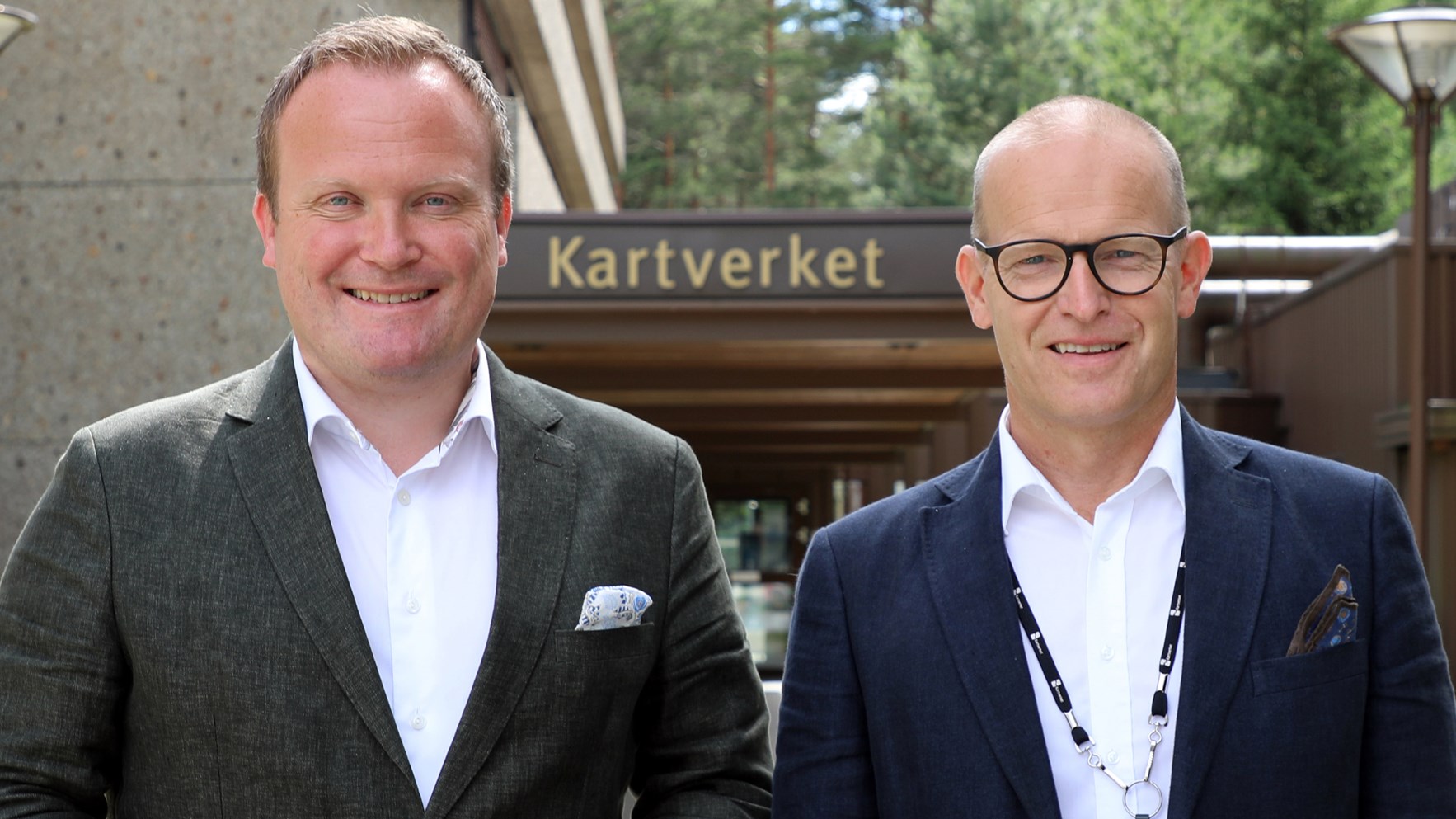 Hans Petter Aasen og Johnny Welle st&aring;r foran inngangen til Kartverkets hovedkontor p&aring; H&oslash;nefoss.