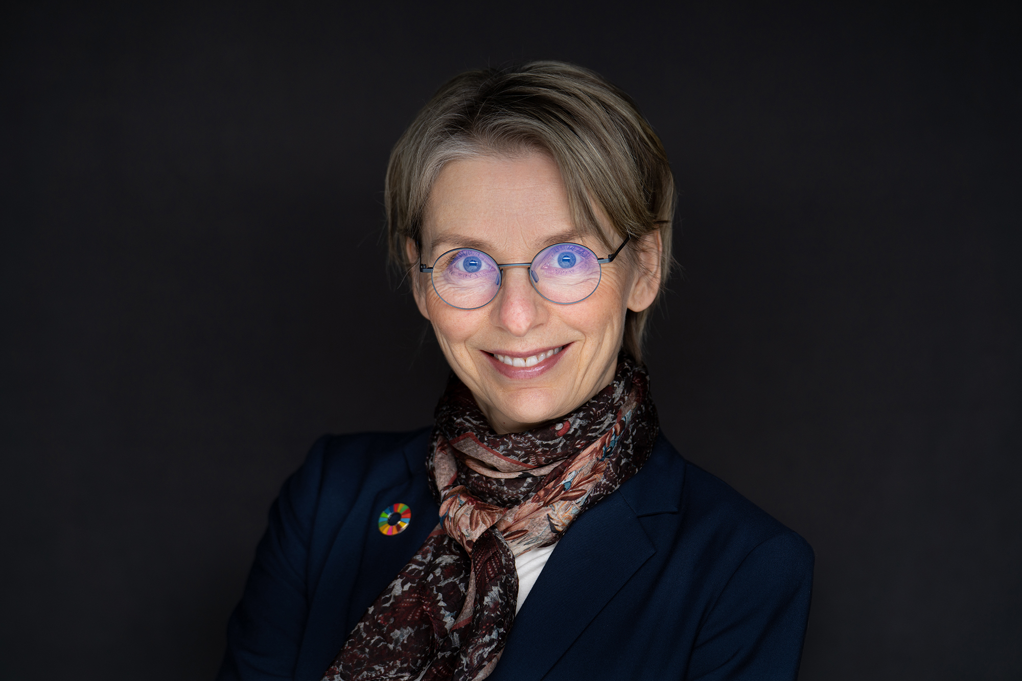 Kvinnelig ansatt i Kartverket i pent t&oslash;y ser rett inn i kamera