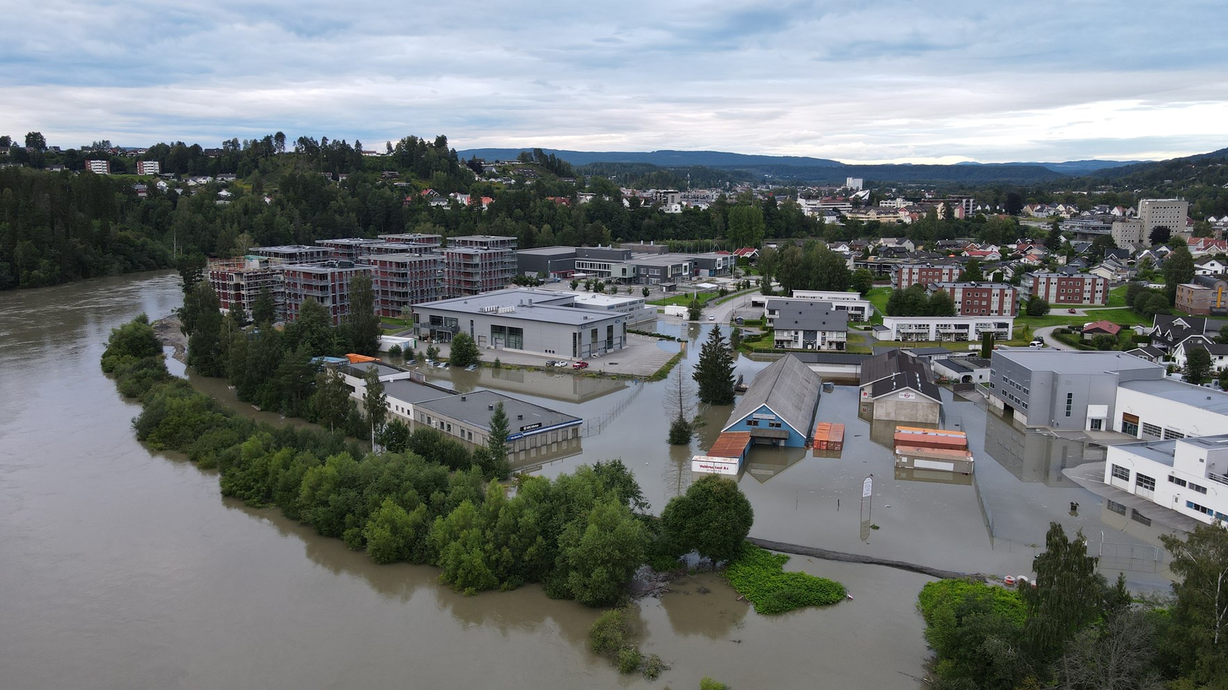 Et bilde som viser oversvømte gater og bygninger i Hønefoss.Foto: Snorre Selmer