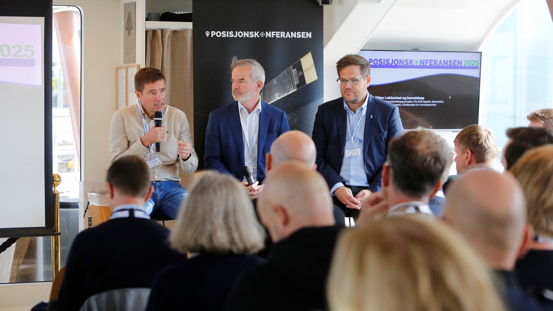 Per Erik Opseth, Jon Halvorsen og Christian Hauglie-Hanssen sitter foran publikum på Posisjonskonferansen. Per Erik snakker i en mikrofon.