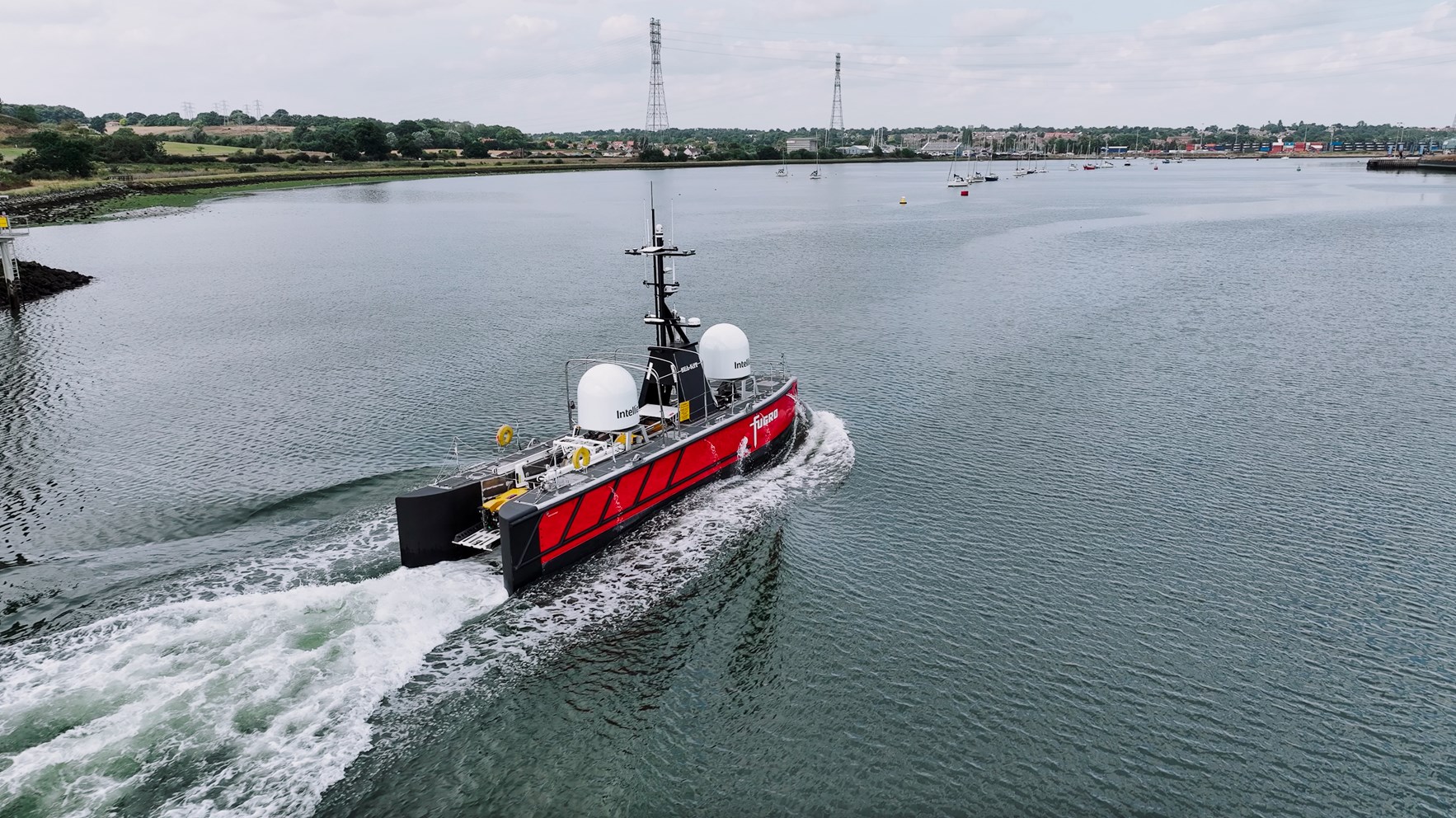 Ubemannet overflatefartøy (USV) seiler i et havnebasseng i retning mot ei havn.
