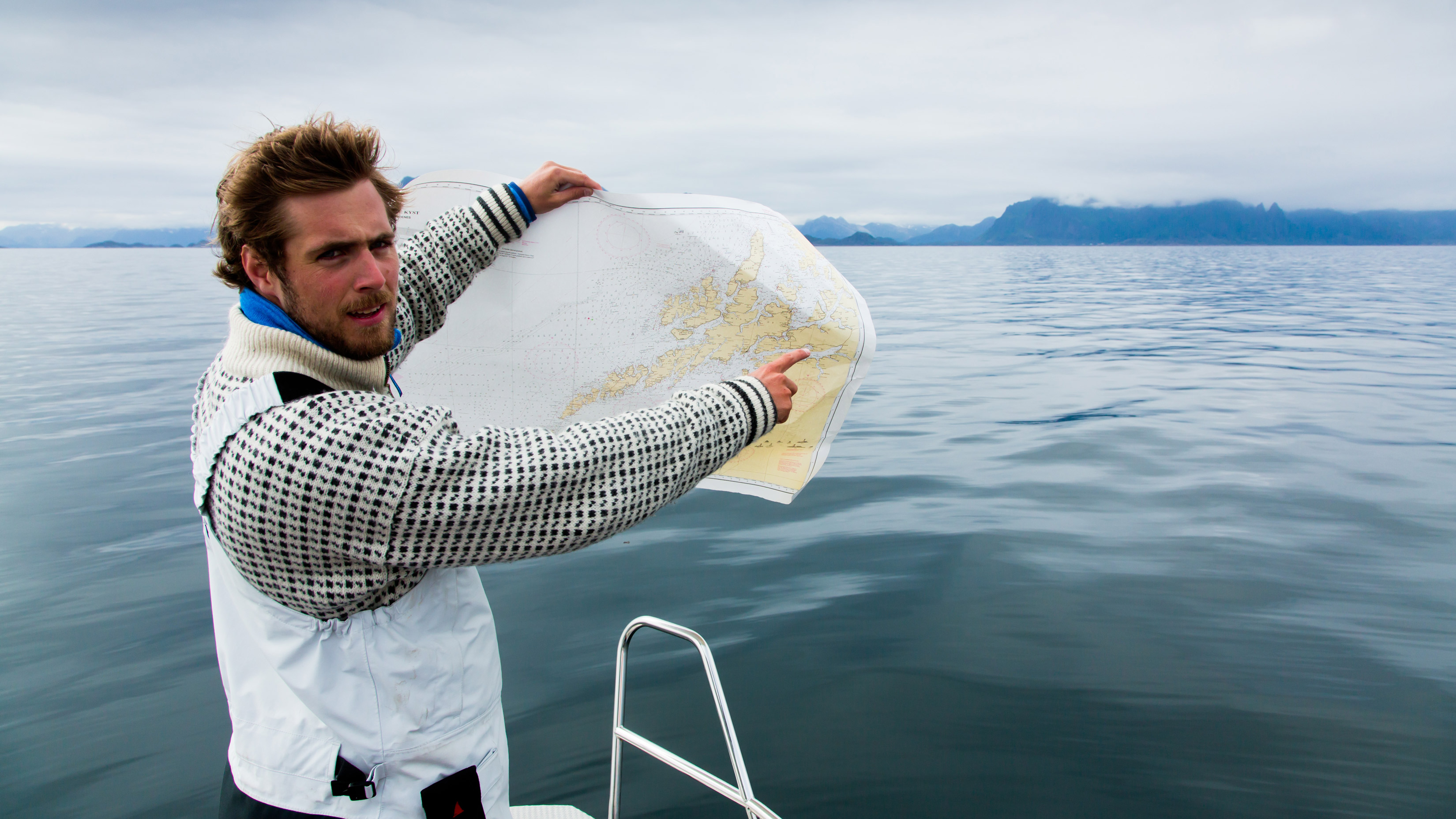 Man on a boat pointing in a coastal chart. Photo: Espen Mills