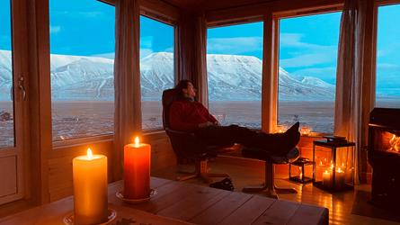 Person som sitter i vindu med utsikt utover Longyearbyen, Svalbard